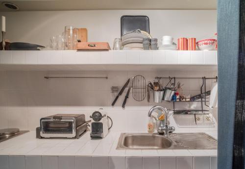 un comptoir de cuisine avec un évier et un micro-ondes dans l'établissement Charmant Studio 2 pers à Paris, à Paris
