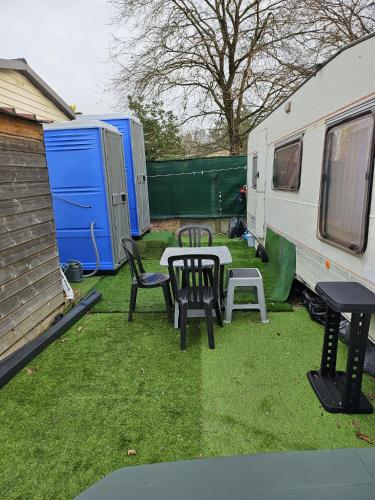 - une table de pique-nique et des chaises à côté d'une remorque dans l'établissement Grande Caravane résidentielle, à Eysines