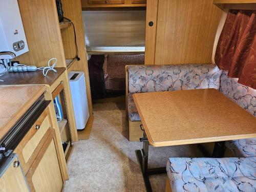 a small kitchen with a table in an rv at Grande Caravane résidentielle in Eysines