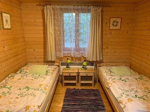 a bedroom with two beds and a table in it at Útulná chata na horách in Valašské Klobouky