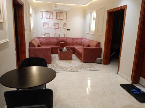 a living room with a couch and a table at دار السلام للشقق المخدومة الجوف دومة الجندل in Dawmat al Jandal