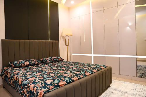 um quarto com uma cama e um candeeiro em Grande Deluxe Luxury Apartment em Rawalpindi
