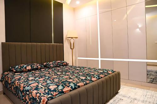 - une chambre avec un lit et une lampe dans l'établissement Deluxe Luxury Apartment, à Rawalpindi