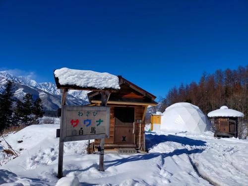 a sign in the snow in front of a igloo at 白馬森のわさび農園オートキャンプ場 in Hakuba