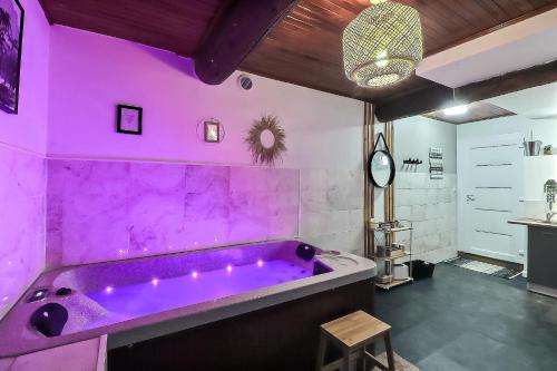 - une baignoire pourpre dans une chambre avec une table dans l'établissement Lâcher-prise SPA, à Bouillargues