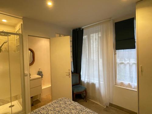 une chambre avec un lit, une fenêtre et une chaise dans l'établissement Charmant et tranquille plein centre de Paris!, à Paris