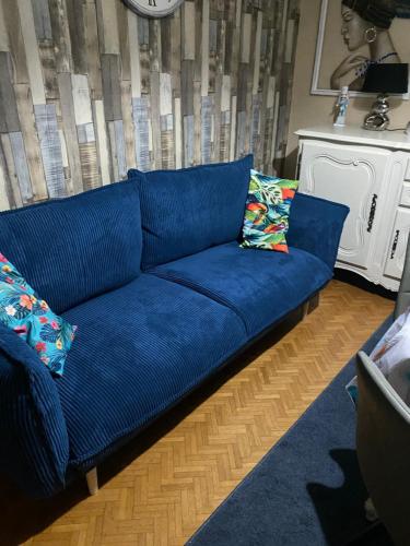 eine blaue Couch im Wohnzimmer in der Unterkunft Maison atypique avec un grand terrain !animaux bienvenus !wifi netflix écran plat 4k in Les Forges