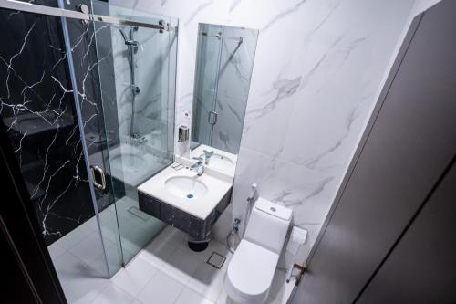 La salle de bains est pourvue de toilettes, d'un lavabo et d'une douche. dans l'établissement فندق كنانة العزيزية من سما, à La Mecque