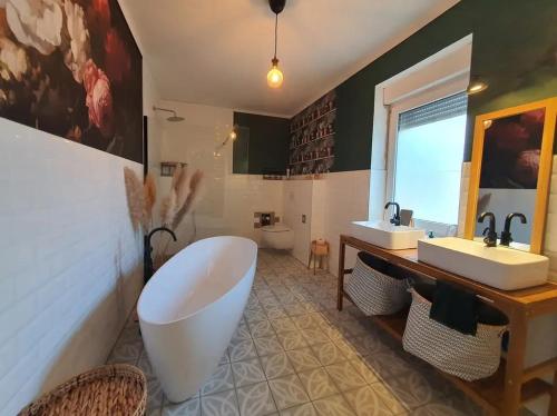 ein Badezimmer mit einer großen Badewanne und 2 Waschbecken in der Unterkunft Haus Natur in Markranstädt