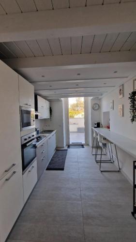 a large kitchen with white cabinets and a counter top at La casa dei Capperi - The house of capers 1 in Acireale