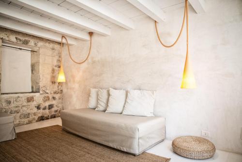 a room with a bed with pillows and a stool at CASA TALIA - Rooms in Modica