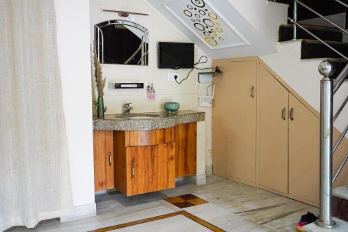 a bathroom with a sink and a tv on a wall at The Basera in Rishīkesh