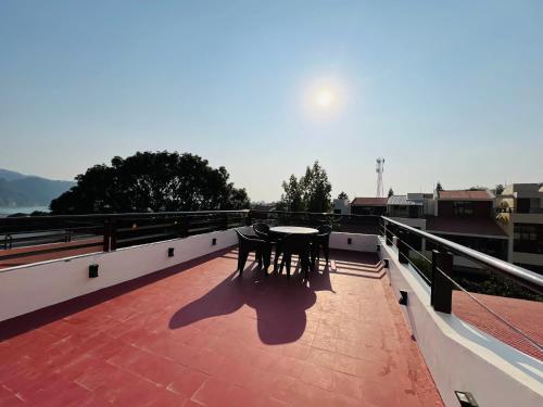 a balcony with a table and chairs on a roof at The Basera in Rishīkesh