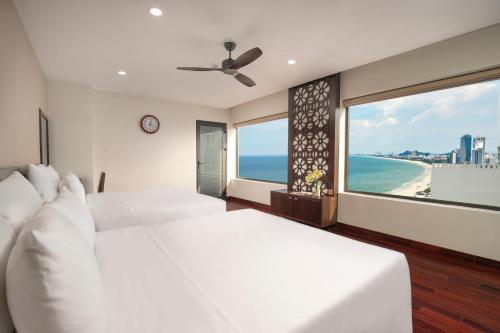 a bedroom with two beds and a view of the beach at Palazzo Boutique Hotel in Da Nang