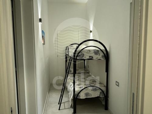 een zwart ijzeren stapelbed in een witte kamer bij Marks House - Spiaggia a 300m By Cala Salento in Porto Cesareo