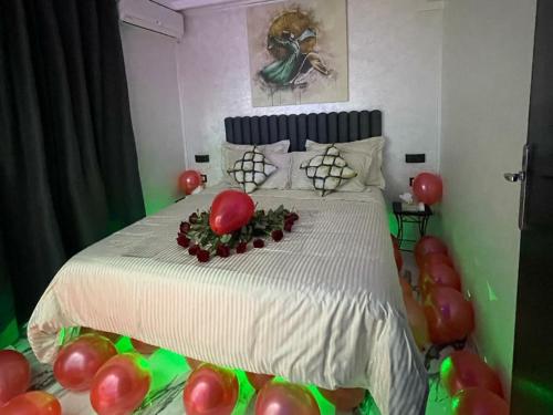 a bedroom with a bed with red and green balloons at Hotel LAHLOU riad Cafeteria in Oujda