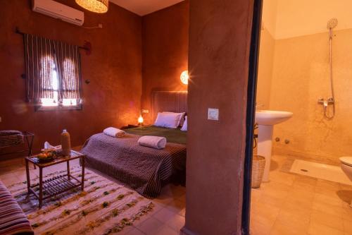 a bedroom with a bed and a bathroom at Hotel Kasbah Sahara in Mhamid