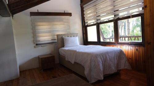 Schlafzimmer mit einem Bett und einem Fenster mit Jalousien in der Unterkunft ÇINARSUYU OTEL- Sosyal Tesisleri in Unye