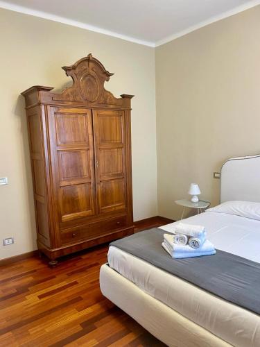 a bedroom with a bed and a wooden cabinet at A Ca' di Rosetta in Albenga