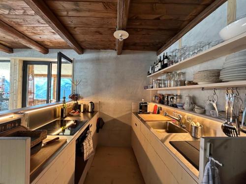 Bijoux in the Swiss mountains في Vna: مطبخ كبير مع مغسلتين ومكتب