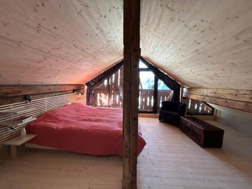 een slaapkamer met een rood bed op zolder bij Bijoux in the Swiss mountains in Vna