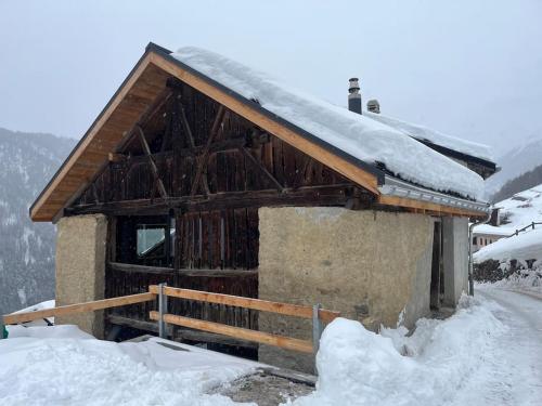 a cabin with snow on the roof of it at Bijoux in the Swiss mountains in Vna