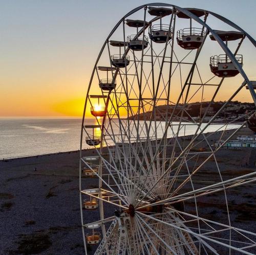 a ferris wheel on the beach at sunset at Petit studio plage Le galet bleu in Le Havre