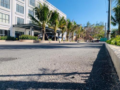 an empty street in front of a building with palm trees at Bờ Biển Vàng Resort in Ke Ga