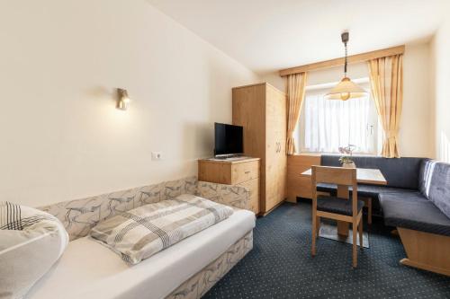 a hotel room with a bed and a desk and a couch at Kedul Lodge in Santa Cristina in Val Gardena