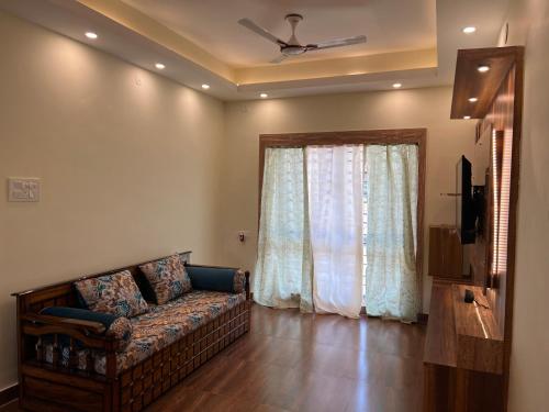 a living room with a couch and a window at Sreemati - A Tranquil Villa in Shānti Niketan