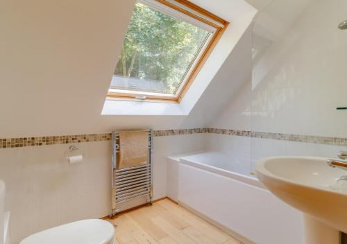 uma casa de banho com um WC e uma janela. em Vale View em Hollesley
