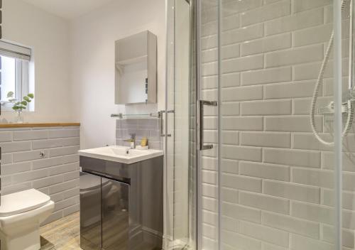 a bathroom with a shower and a sink and a toilet at Seascape Cottage in Reydon