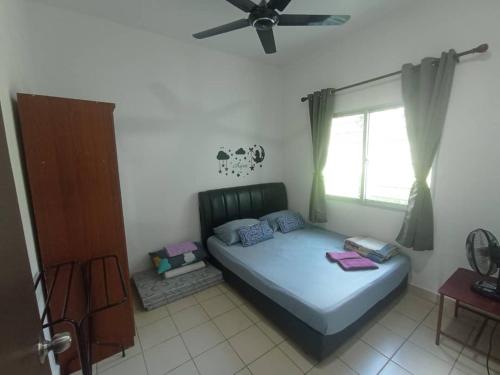 a bedroom with a bed and a ceiling fan at AA HOMESTAY TAWAU in Kampong Parit
