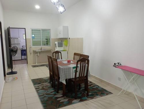 a dining room with a table and chairs in a kitchen at AA HOMESTAY TAWAU in Kampong Parit