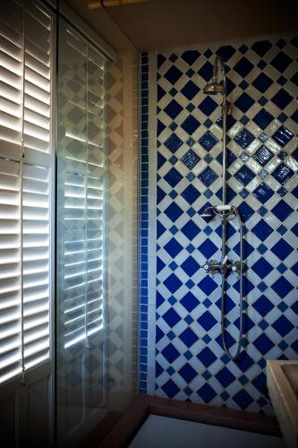 a bathroom with a shower with blue and white tiles at CASA TALIA - Rooms in Modica