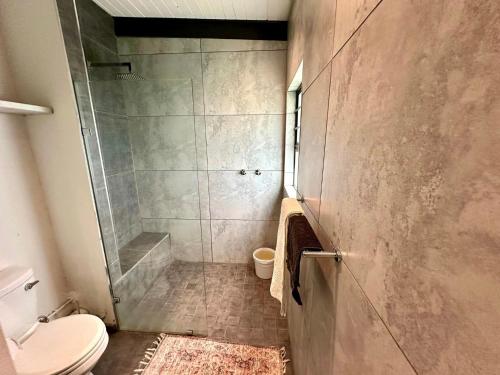 a bathroom with a shower and a toilet at Hadada Self Catering Studio in Haga-Haga