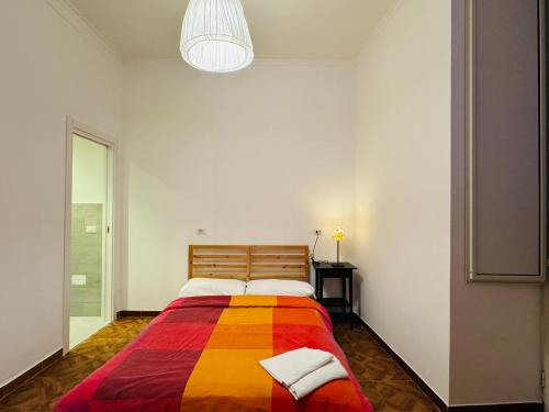 Hostel Mancini Naples في نابولي: سرير مع بطانية ملونة في الغرفة
