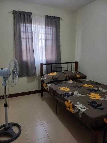 a bedroom with a bed and a fan in a room at Affordable 2 BR Transient House in Lipa City Batangas in Lipa