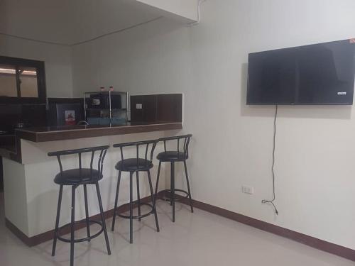 a kitchen with four bar stools at a counter at Affordable 2 BR Transient House in Lipa City Batangas in Lipa