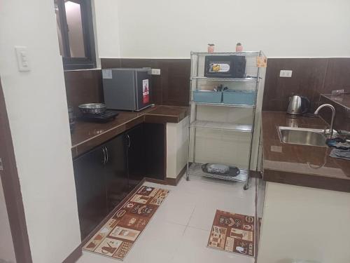 a small kitchen with a sink and a microwave at Affordable 2 BR Transient House in Lipa City Batangas in Lipa