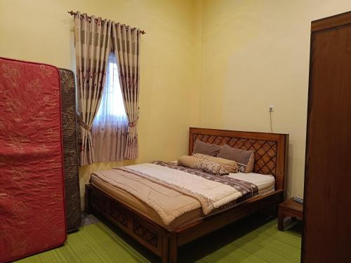 um quarto com uma cama e uma janela em Omah Gunung Homestay em Batur