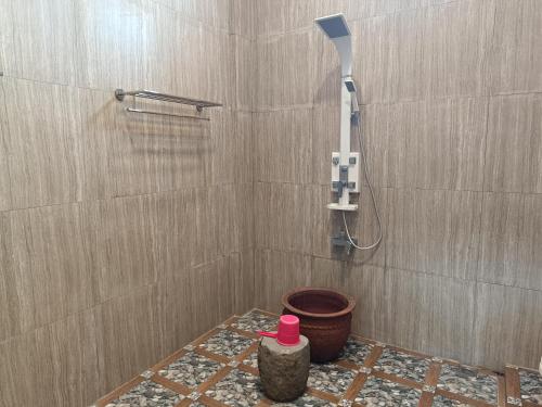 uma casa de banho com um chuveiro, um WC e um balde em Omah Gunung Homestay em Batur