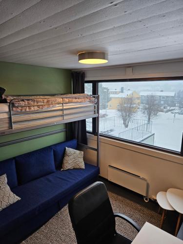 een kamer met een stapelbed en een blauwe bank bij Trivelig studioleilighet på byåsen med treningsrom, uteareal og parkering in Trondheim