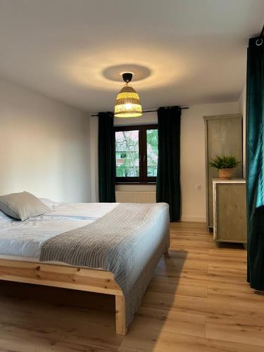a bedroom with a bed and a large window at Apartament Jeziorna in Ocypel
