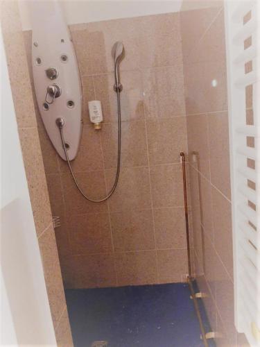a shower with a hose attached to a tiled wall at Mehrbett-Apartment 7 Citynah, einfache Ausstattung in Hamburg