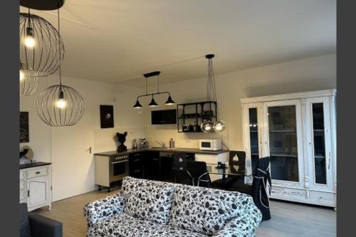 ein Wohnzimmer mit einem Sofa und einer Küche in der Unterkunft Ferienwohnung Rose 42 Citynah, gehobene Ausstattung in Hamburg