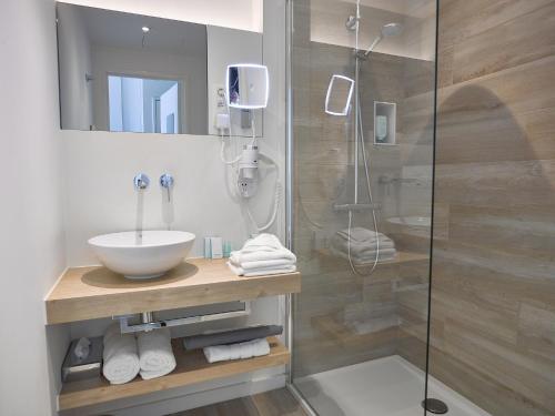 a bathroom with a sink and a shower at Hotel De Kommel in Voeren