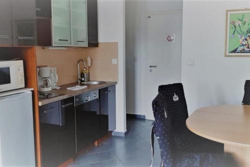 eine Küche mit einem Tisch, einem Tisch und einer Mikrowelle in der Unterkunft Mehrbett-Apartment 3 Citynah, einfache Ausstattung in Hamburg
