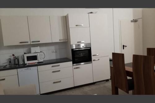 a kitchen with white cabinets and a stove top oven at Apartment 41 Citynah, Bad extern, einfache Ausstattung in Hamburg