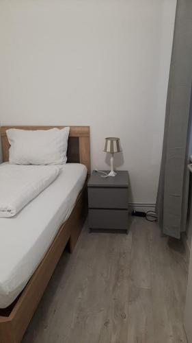 a bedroom with a bed and a lamp on a night stand at Apartment 41 Citynah, Bad extern, einfache Ausstattung in Hamburg
